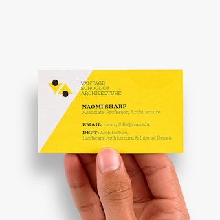 A hand holding a custom business card printed with Vantage School of Architecture in black text.