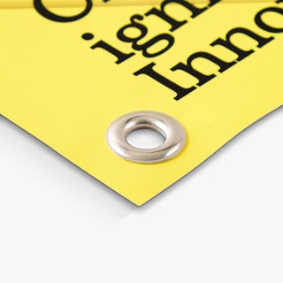 The bottom corner of a hanging banner with a grommet and yellow and black design.