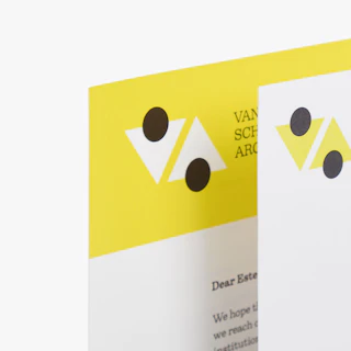 The top left corners of a school letter mailer and matching envelope printed in yellow, white and black.