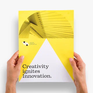Two hands holding a school letterhead printed with a white and yellow background and black text.