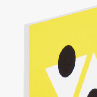 The top corner of a PVC foam sign custom printed with a yellow, black and white design.