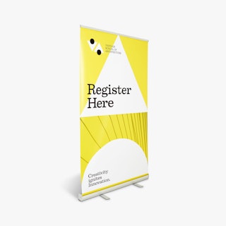 A retractable banner printed in yellow and white with Register Here in black and a silver stand.