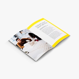 A school saddle stitch booklet laying open to an image of two people sitting at a table with a model on it.