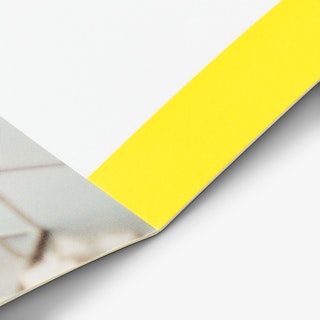 A custom booklet laying open with a saddle stitch binding and pages printed in yellow, white and tan.