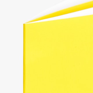The top left corner of a saddle stitched booklet printed with a bright yellow cover.