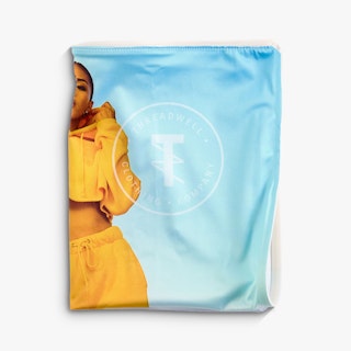 An SEG wall graphic folded and printed with a woman in a yellow outfit and a blue background,