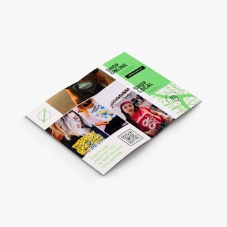 A folded self-mailer laying open to images of people wearing T-shirts and a map to a retail store.