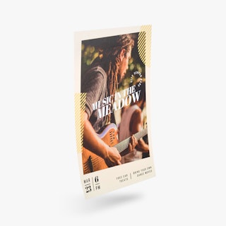 A custom event poster printed with Music in the Meadow in white and a man playing the guitar.