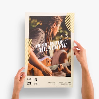 Two hands holding an event poster custom printed with Music in the Meadow and a man playing guitar.