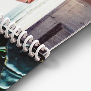 A printed booklet laying open with a white spiral binding.