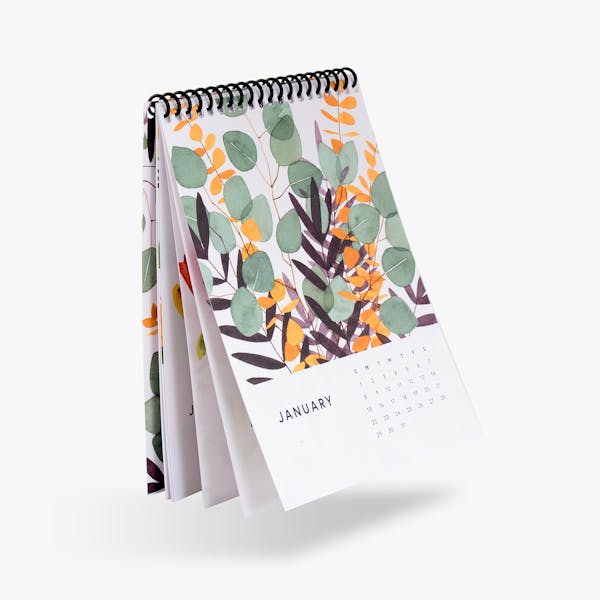 A spiral bound calendar printed with an orange, green and purple floral design on the cover.