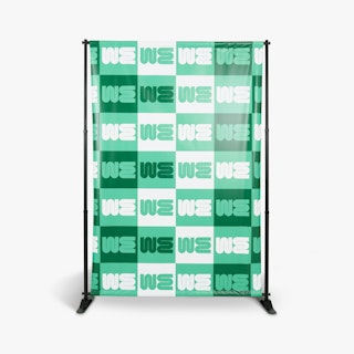 A step and repeat backdrop printed with a white, light green and dark green design and a black stand.