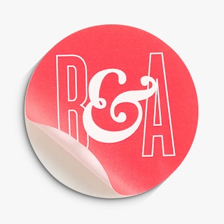 A bright pink and white sticker seal printed with B & A in the middle and peeling off its backing.