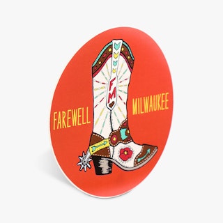 A round sticker custom printed with an orange background, cowboy boot and Farewell Milwaukee.