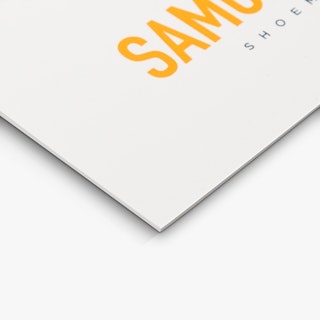 The bottom corner of a styrene sign custom printed with a white background and orange letters.