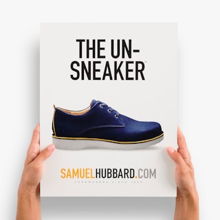 Two hands holding a custom styrene sign printed with The Un-Sneaker and an image of a shoe.
