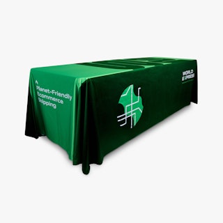 A custom table throw draped over a table and printed with a green and white World Express design.