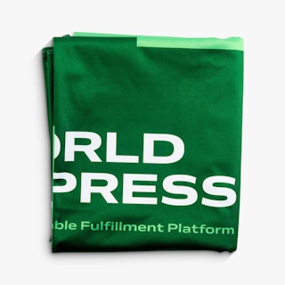 A folded table throw printed in dark and light green with World Express in white.