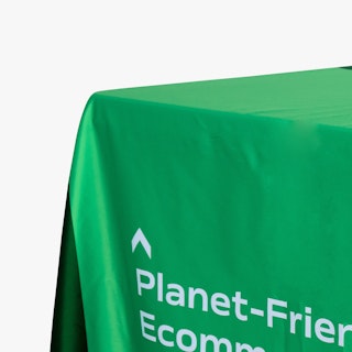 The corner of a custom table throw printed in light green and dark green with white text.