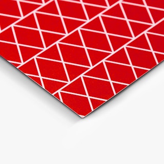 The bottom corner of a custom thank you card printed with a red and white geometric design.