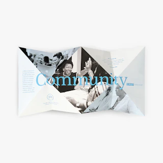 An unfolded brochure with a specialty tulip fold printed with Community in blue on the inside.