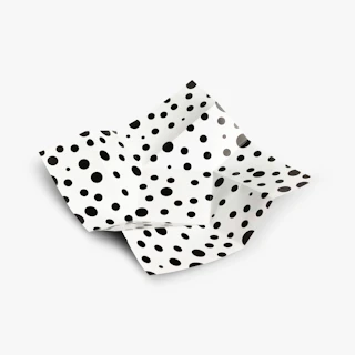 An unfolded direct mail piece with a twisted design and a black polka dot pattern.