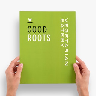 Two hands holding a waterproof menu custom printed with a light green background and Good Roots.