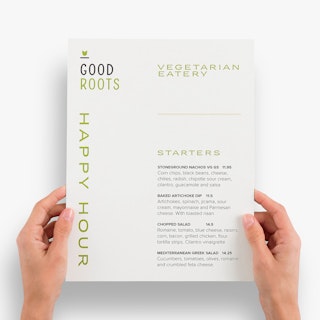 Two hands holding a waterproof menu printed with Good Roots Vegetarian Eatery and starter items.