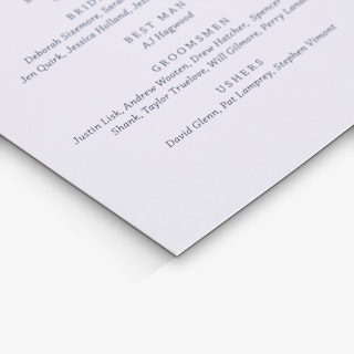 The bottom corner of a custom wedding program printed with names of the best man and groomsmen.
