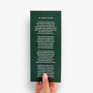 The back of a wedding program printed with a dark green background and a prayer in white.