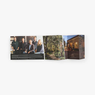An accordion brochure with a stepped design laying flat with images of a group of people and a home.